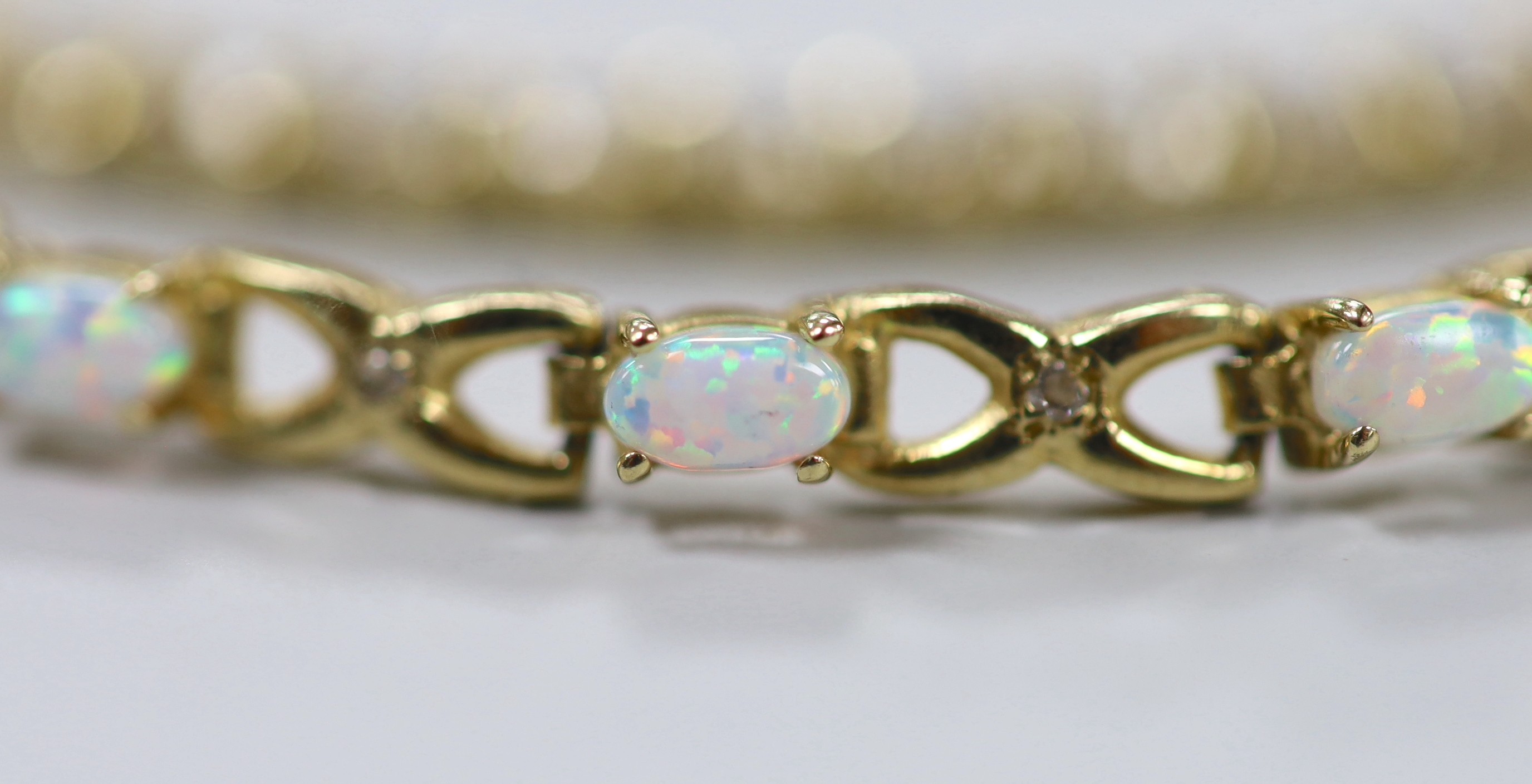 A modern 14k yellow metal and simulated diamond set line bracelet, 18cm and a 14k yellow metal and white opal set line bracelet, 18.5cm, gross weight 19.5 grams.